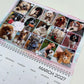 A spiral-bound monthly calendar page for March 2027, featuring a grid of 16 pet photos of various dogs and cats. A small decorative sticker reading is placed on one of the photos.